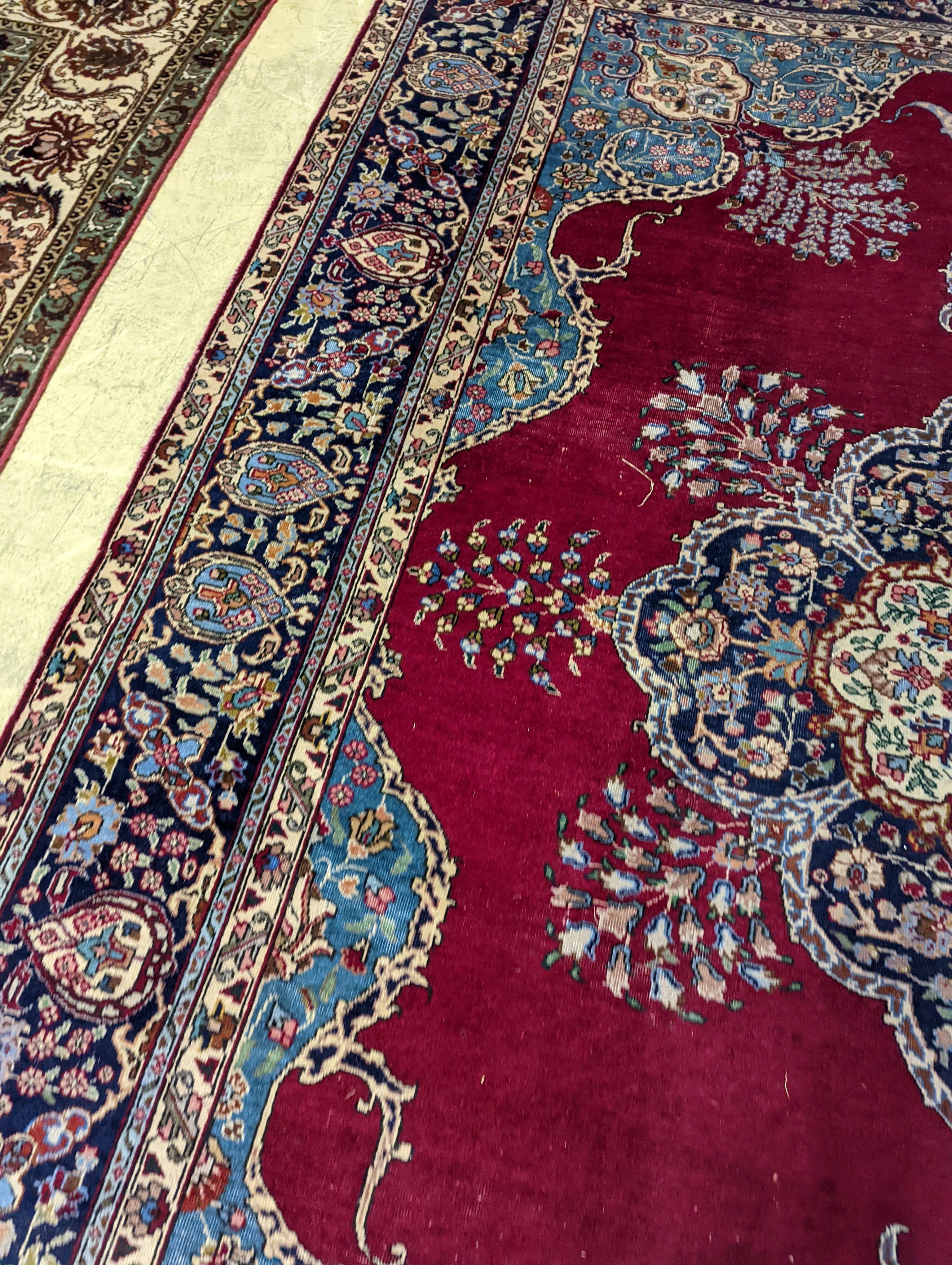 A Tabriz burgundy ground carpet, 350 x 240cm